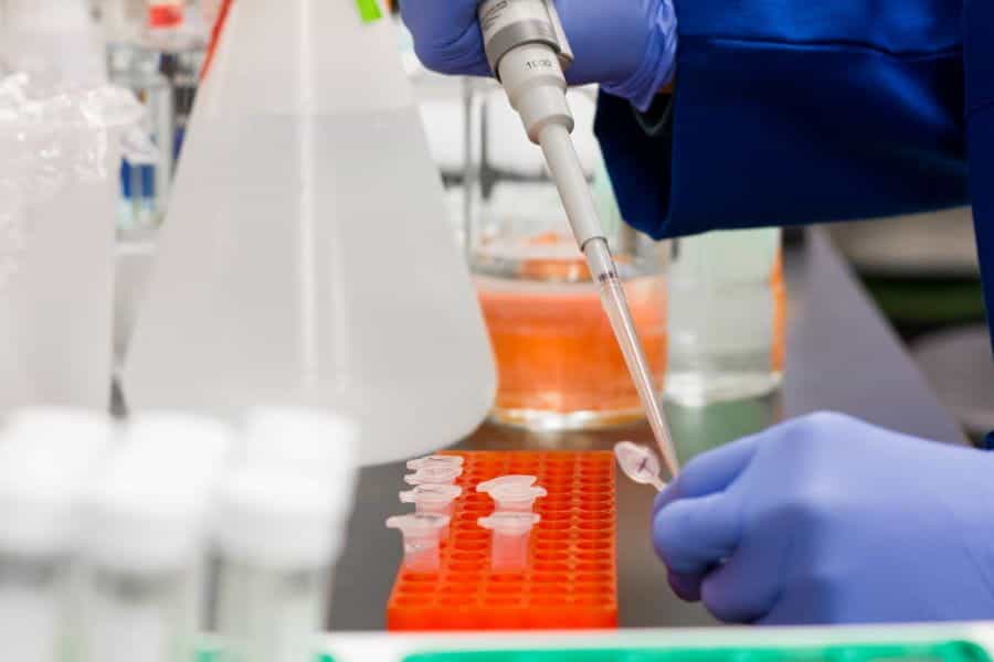 A scientist in a lab, developing a vaccine in test tubes.