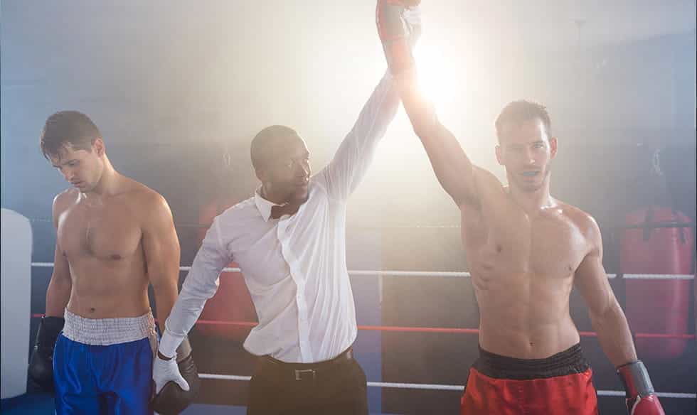 Two boxers, with a referee holding up the winner's arm.