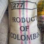 A stack of burlap sacks, with the frontmost labelled PRODUCT OF COLOMBIA.