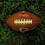 NFL football ball for Atlanta Falcons sits on grass.