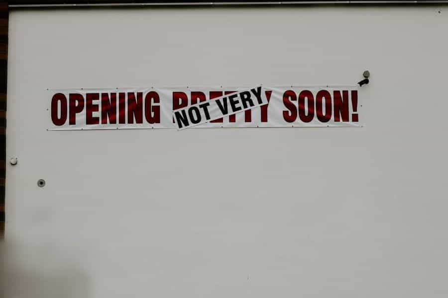 A white wall with a sign reading OPENING NOT VERY SOON.
