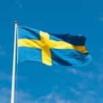 The Swedish flag flying from a flagpole.