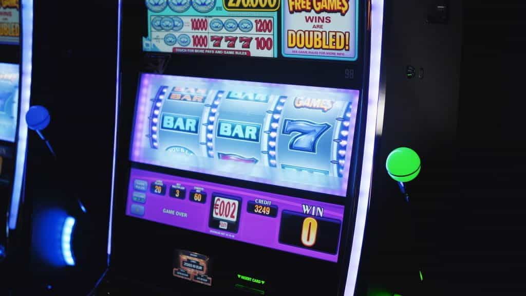 A glowing slot machine in a dark casino.