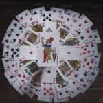 A circle of playing cards with a joker in the middle.