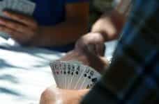 Three men play poker around a table.