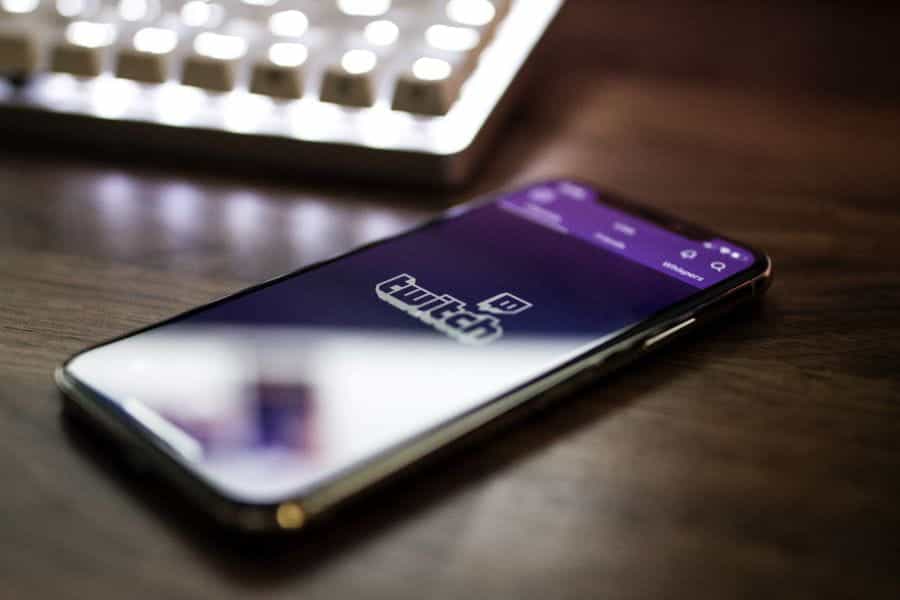 A phone lies on a desk open to the Twitch app.