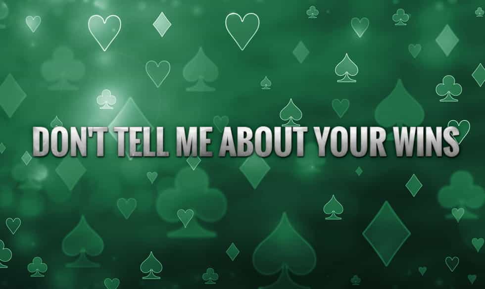 The words "don't tell me about your wins", on a back drop of the four suits of cards.