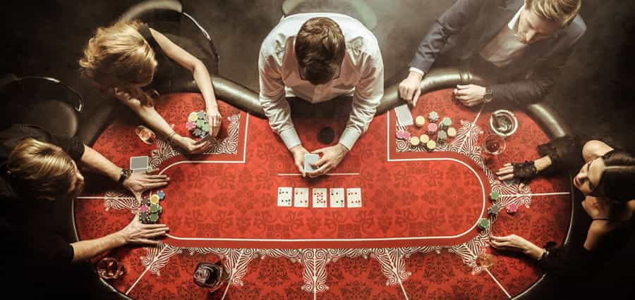 A poker table, with four players and a dealer.