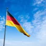 A German flag against a blue sky.