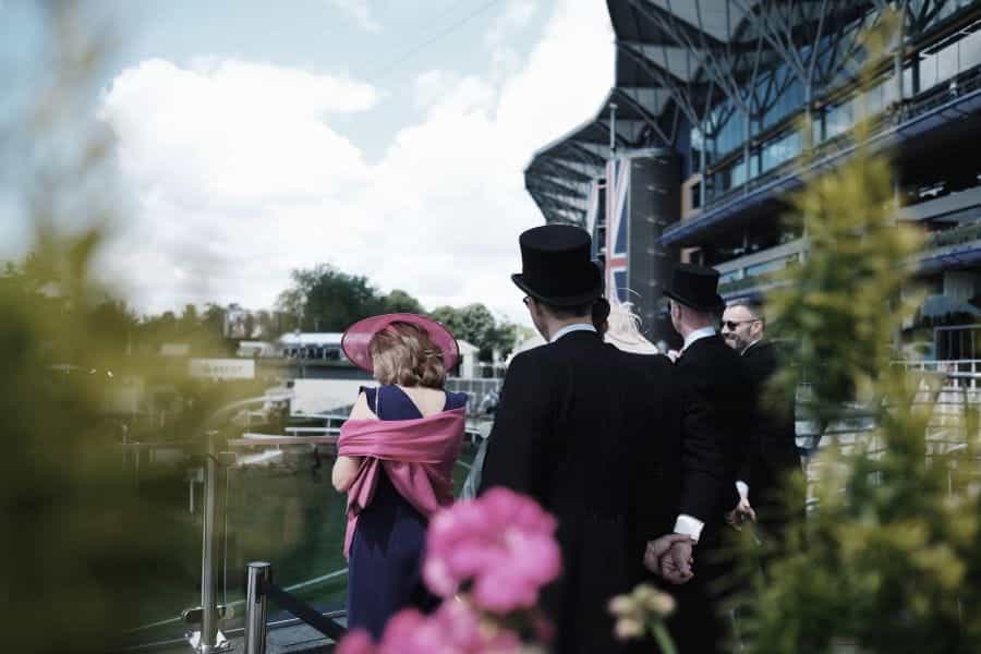Men and women in formal clothes at the Royal Ascot horse race.