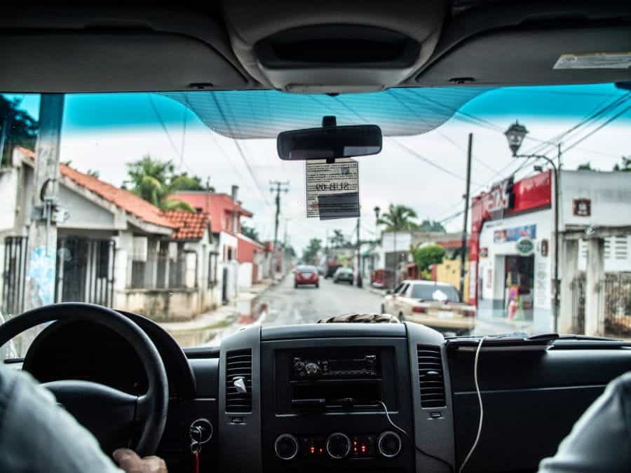 In the backseat of a car driving through a residential street in Mexico.