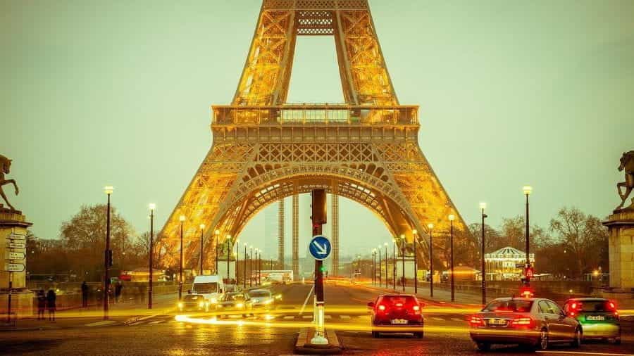 Cars passing under the Eiffel Tower in Paris.