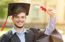 A graduate holding up a certificate.