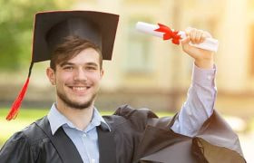 A graduate holding up a certificate.