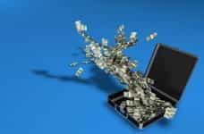Stacks of money fly out of an open briefcase.