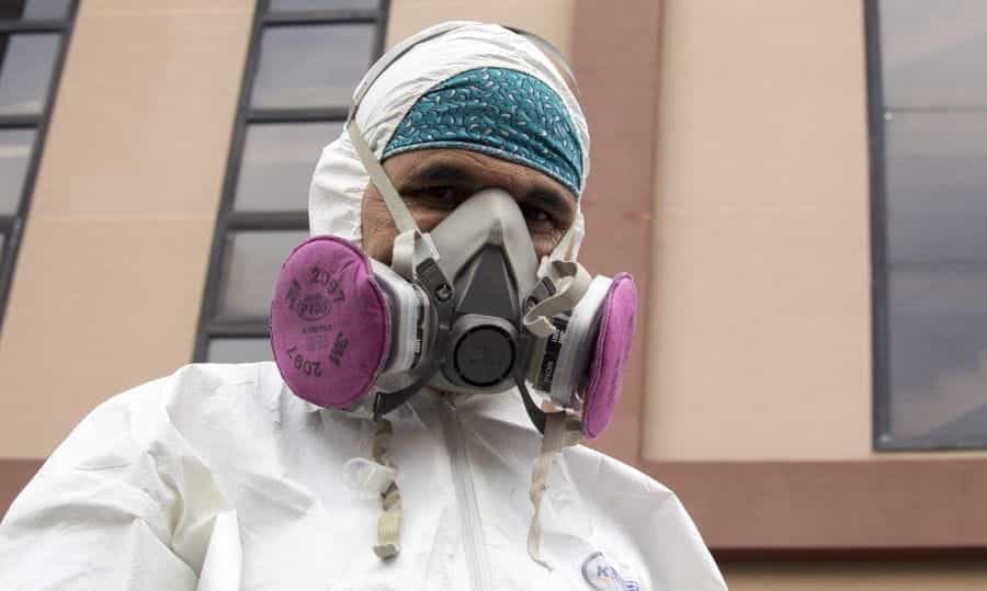 A man in a hazmat suit and gas mask in Venezuela.