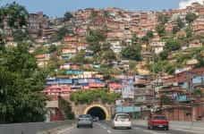 A roadway runs through a mountain of houses in Caracas, Venezuela.