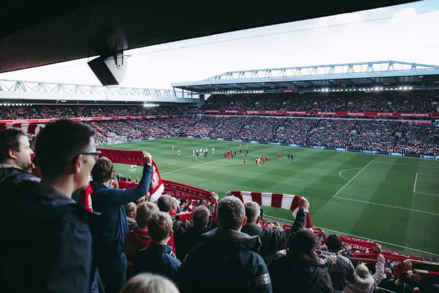 Football fans cheer on a game at a stadium.