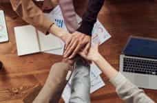 An office team with hands together in center.
