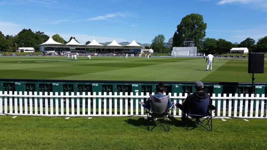 A cricket match being watched by spectators.