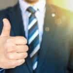 Businessman in suit with thumbs up.