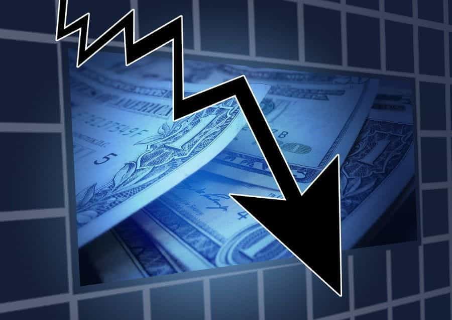 A graphic of a black arrow leading downwards in front of a stack of US dollars, indicating financial crisis.