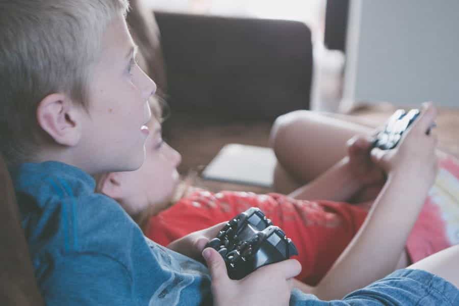 Two children play video games together.