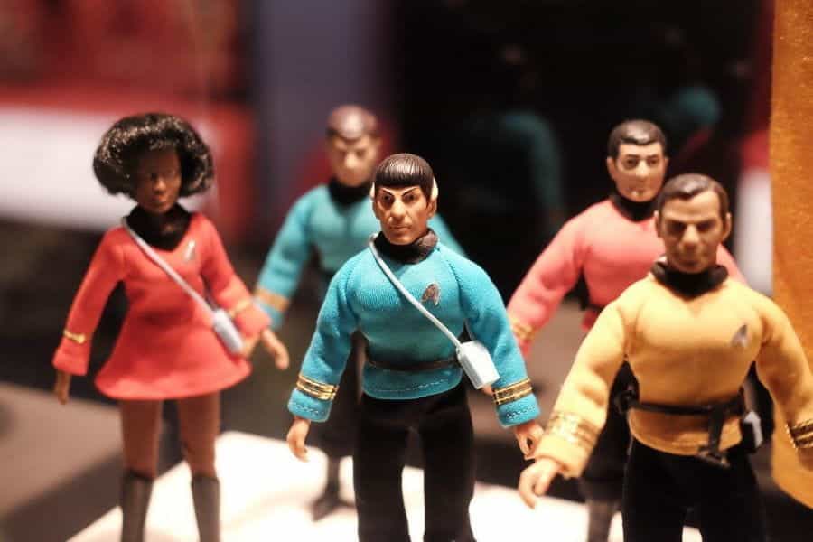 A row of Star Trek action figures stand on a desk.