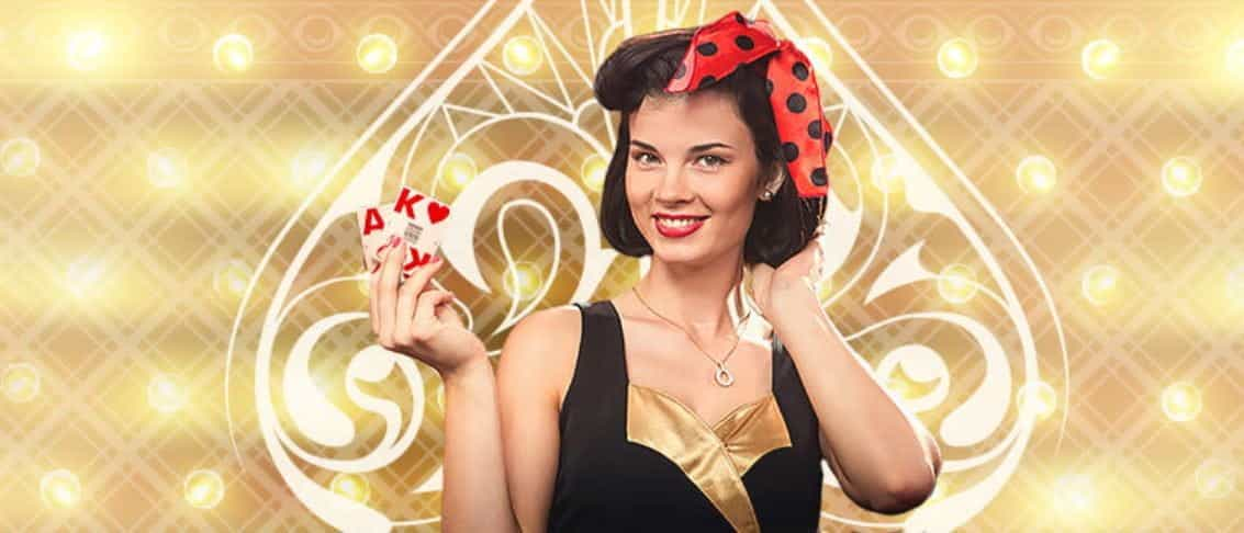 A female casino dealer, wearing a bow in her hair, holding playing cards.