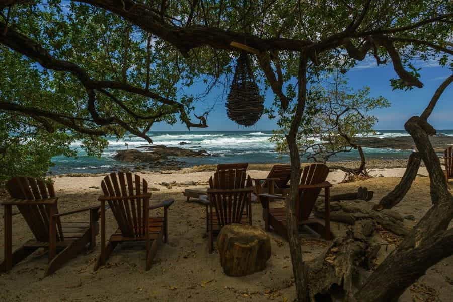 A row of beach chairs look out on the ocean in Costa Rica.
