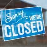 A blue shop sign, reading 'sorry we're closed'.