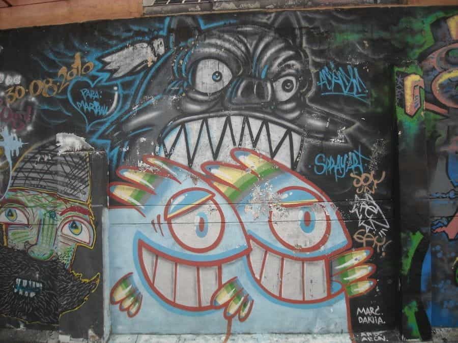 Colorful street art on a black wall in Bogotá, Colombia.