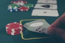 A person looking at their hole cards in a poker game.