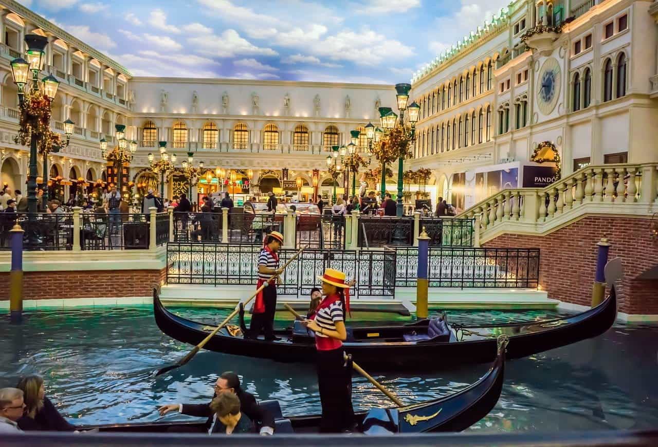 Dua pendayung gondola melayang melewati sebuah "luar ruangan" restoran di The Venetian di Las Vegas.