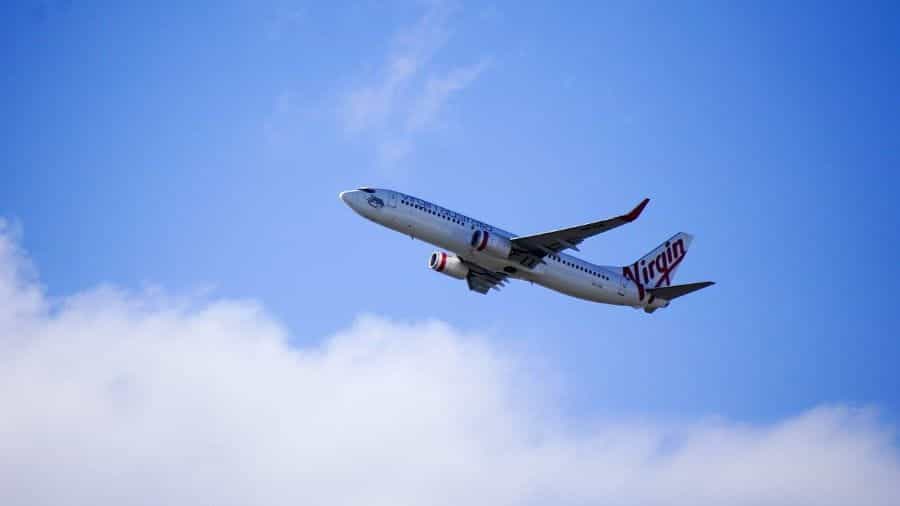 Sebuah pesawat Virgin Australia terbang tinggi di langit.