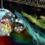 A gleaming disco ball in a dark and colorful club.