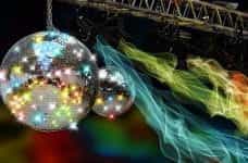 A gleaming disco ball in a dark and colorful club.