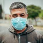 Seorang pria memakai masker pelindung wajah.