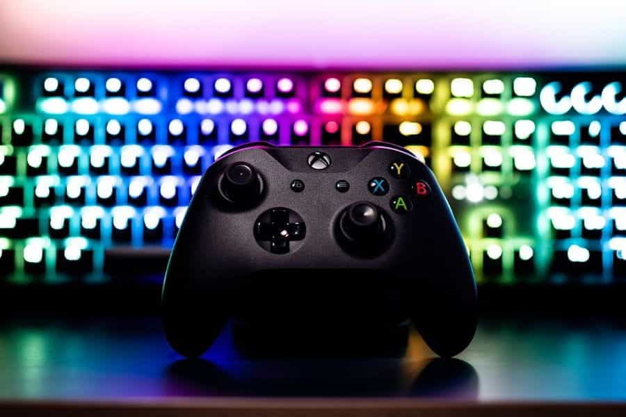 Pengontrol Xbox di depan papan ketik berwarna-warni.