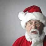 A shocked man dressed as Santa.
