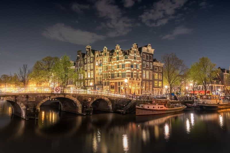 Malam hari di ibu kota Belanda, Amsterdam, dengan salah satu jembatan ikonik kota yang tak terhitung jumlahnya terlihat jelas.