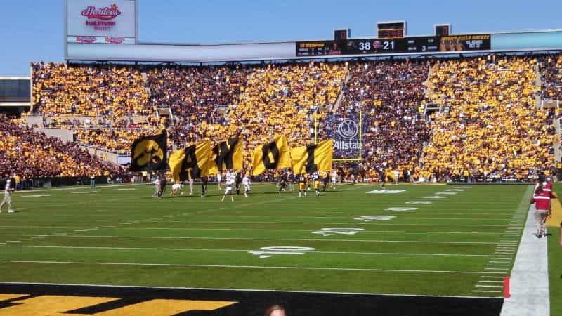 Cheerleaders wave banners on the field of a Hawkeyes football game in a stadium in Iowa City, Iowa.
