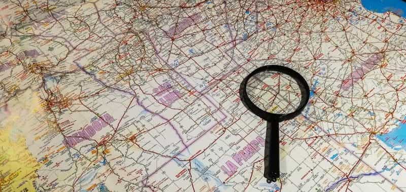A magnifying glass lies on top of a map of Argentina.