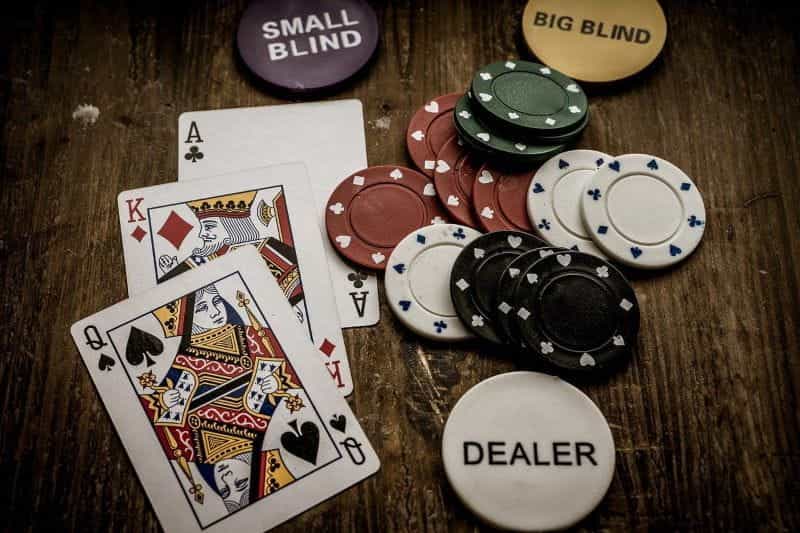 A table is strewn with poker chips and playing cards.