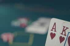 A poker hand (Ace and King) with a poker table in the background.