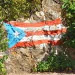Bendera Puerto Rico digambar dengan kapur di dinding batu.