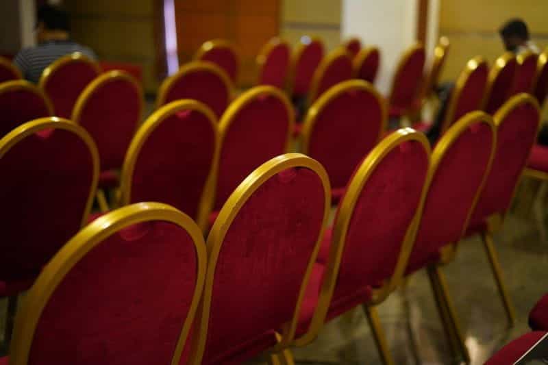 Deretan kursi kosong di aula konvensi.
