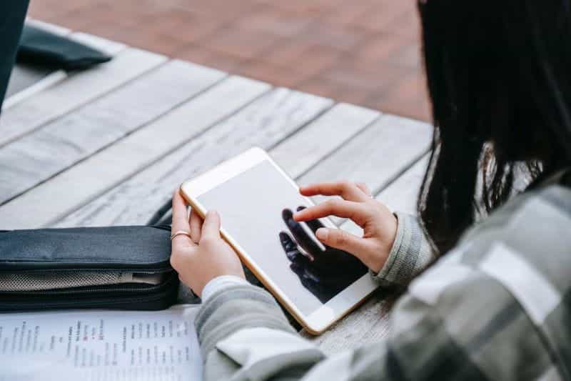 Seorang wanita yang menggunakan komputer tablet di luar.