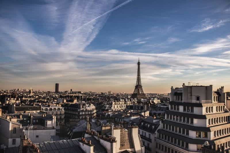 The Parisian skyline underneath a blue sky, with the famous Eiffel Tower prominently on display.