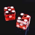 A pair of red dice on a black background.